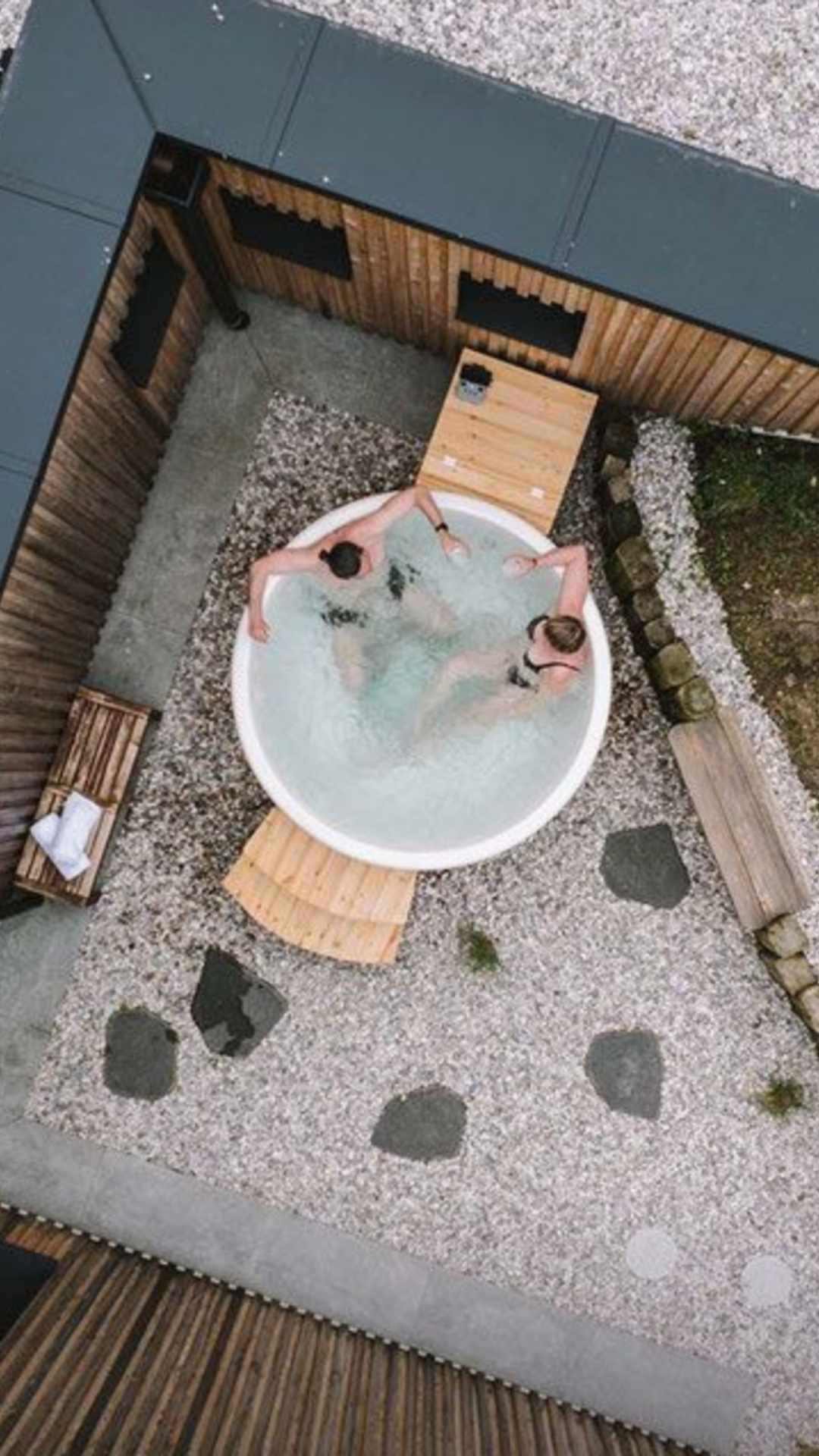 Pár ve venkovní vířivce, která je součástí investičních apartmánů Four Elements Jizerské hory