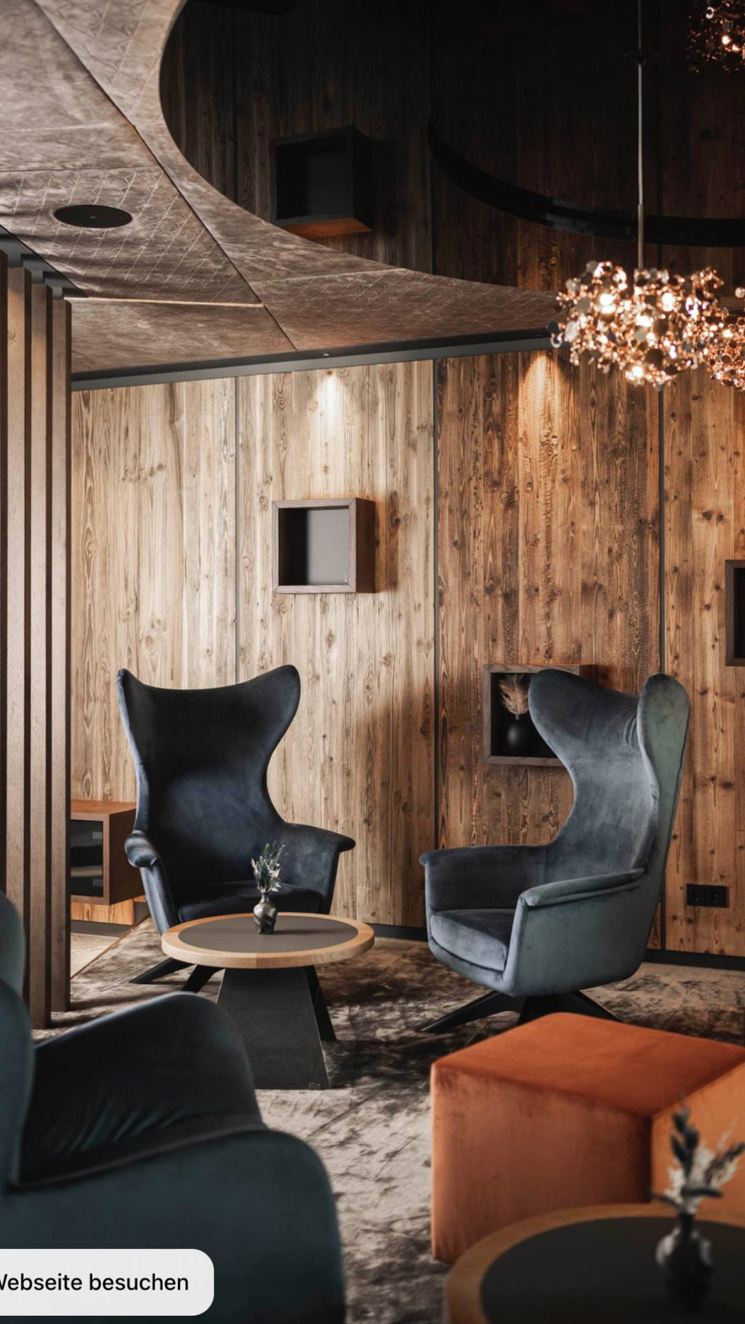 Vizualizace společenské místnosti hotelu Four Elements Hills Hotel & Spa v dřevěním dekoru s černými křesly