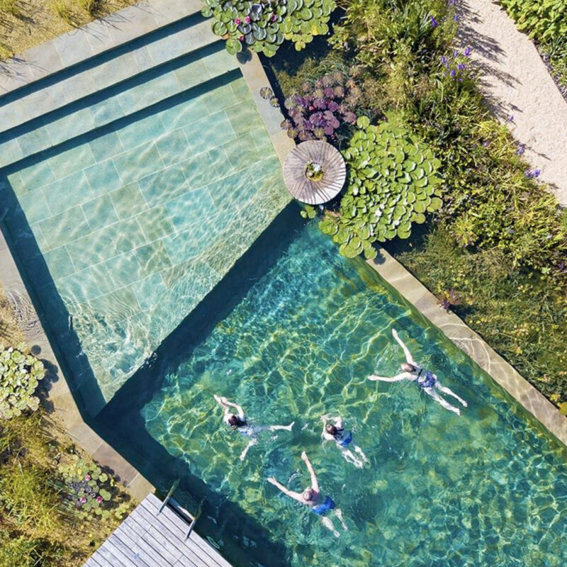 Plavající lidé v bazénu poblíž investičních apartmánů Four Elements Jizerské hory